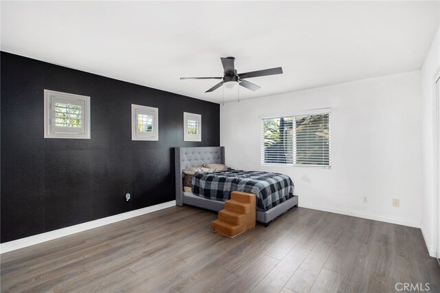 33081 Yucca St, Temecula, CA 92592 - bedroom featuring wood finished floors, a ceiling fan, and an accent wall