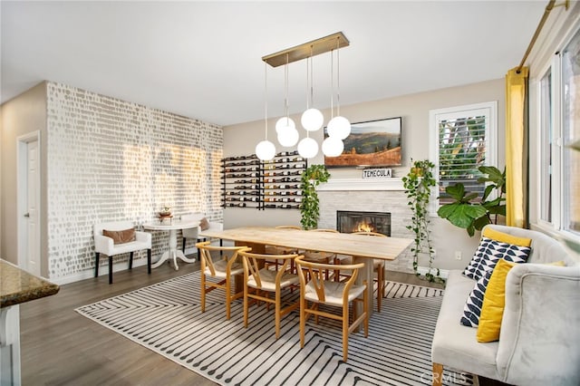 33081 Yucca St, Temecula, CA 92592 - dining space featuring wood finished floors, a tiled fireplace, and baseboards