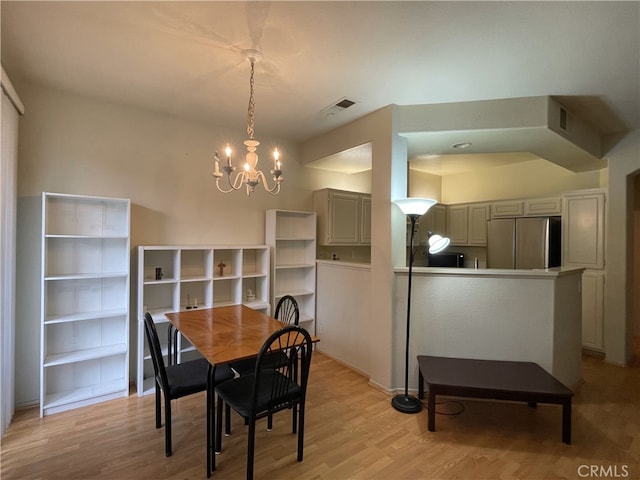 dining room featuring visible vents, light wood-type flooring, and a chandelier