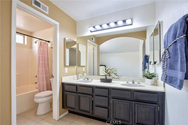 bathroom featuring toilet, tile patterned flooring, a sink, and visible vents