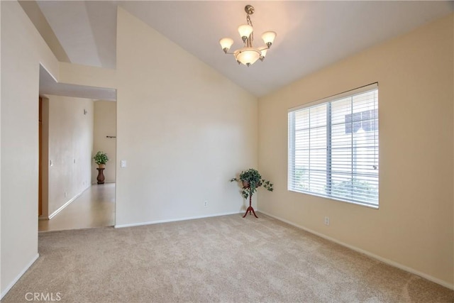 carpeted spare room with lofted ceiling, baseboards, and a notable chandelier