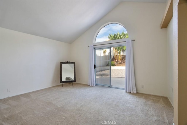 spare room featuring high vaulted ceiling and carpet floors