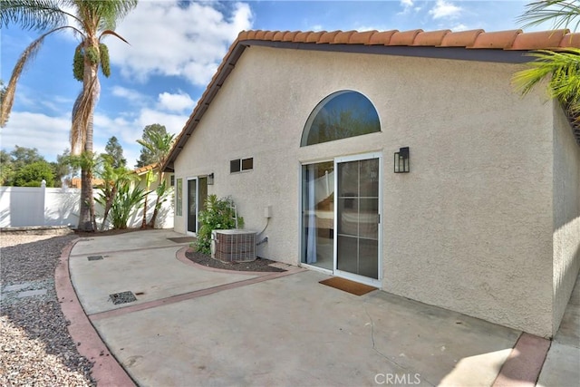 rear view of house featuring fence, a patio, central AC unit, and stucco siding
