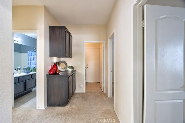 corridor featuring baseboards and light colored carpet