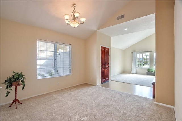 carpeted empty room featuring baseboards, vaulted ceiling, visible vents, and an inviting chandelier