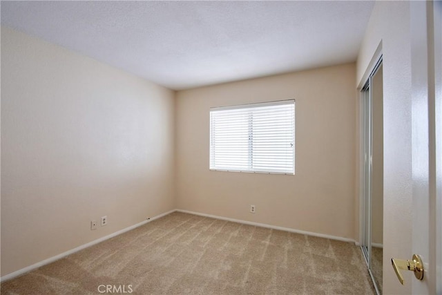 unfurnished room featuring baseboards and carpet