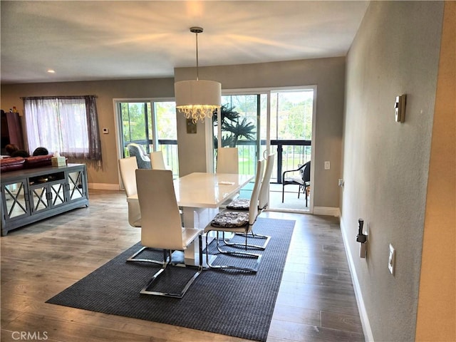 dining room featuring recessed lighting, wood finished floors, baseboards, and a notable chandelier