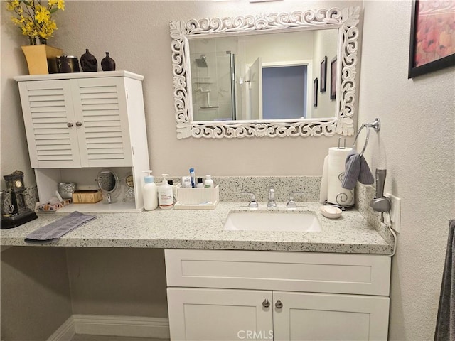 full bath featuring a textured wall, vanity, and a stall shower