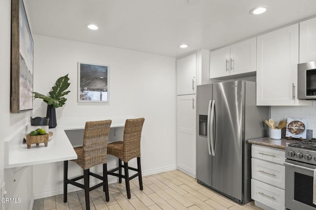 2515 Harbor Blvd Unit 1, Ventura, CA 93001 - kitchen with stainless steel appliances, white cabinets, baseboards, recessed lighting, and backsplash