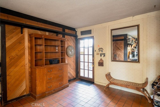 entryway with a textured ceiling and tile patterned floors