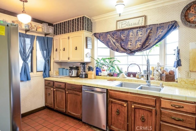 kitchen featuring stainless steel appliances, a sink, ornamental molding, and wallpapered walls