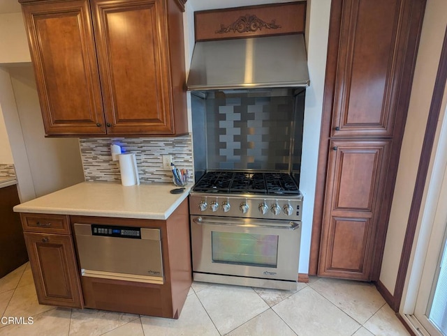 636 N C St, Oxnard, CA 93030 - kitchen with under cabinet range hood, high end range, light tile patterned flooring, light countertops, and tasteful backsplash