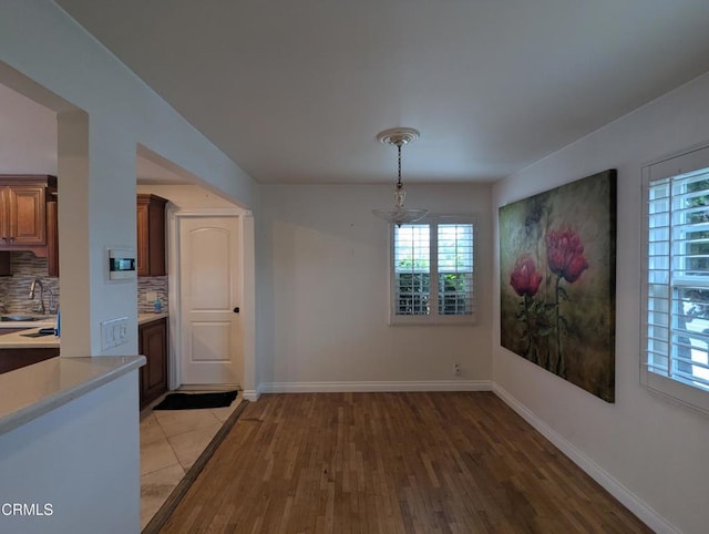 636 N C St, Oxnard, CA 93030 - unfurnished dining area featuring baseboards, a wealth of natural light, light wood-style floors, and a sink