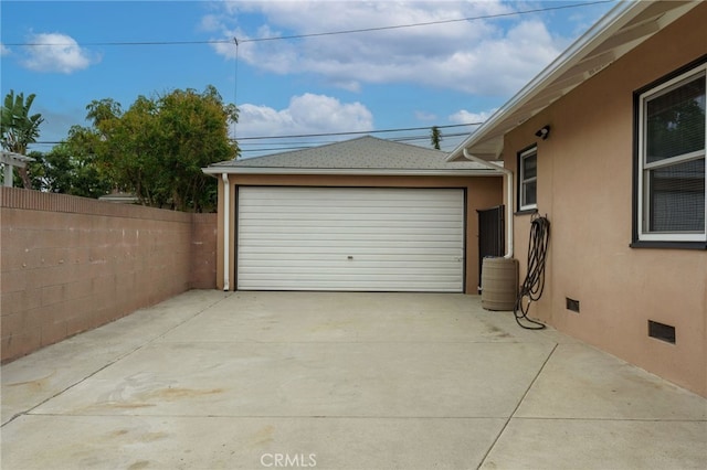 detached garage featuring fence