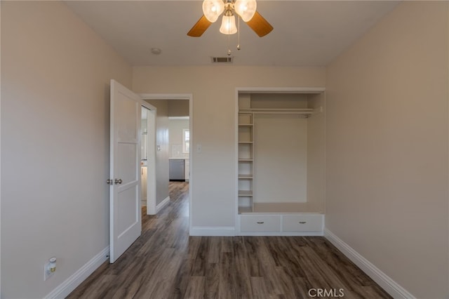 unfurnished bedroom with dark wood-style floors, visible vents, a ceiling fan, a closet, and baseboards
