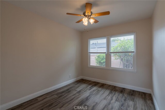 spare room featuring baseboards, a ceiling fan, and wood finished floors