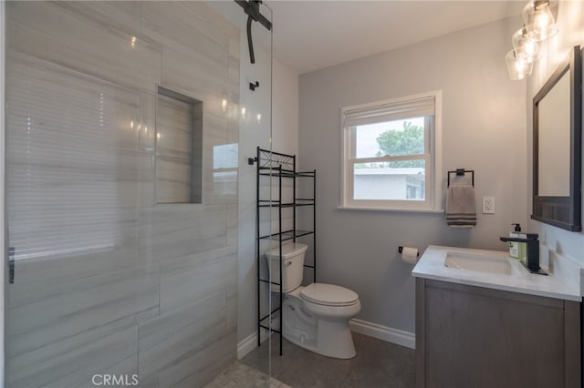 bathroom featuring vanity, baseboards, toilet, tile patterned flooring, and a walk in shower