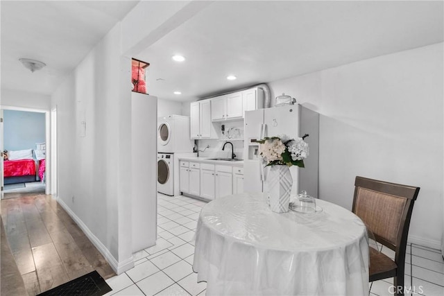 dining room featuring recessed lighting, baseboards, and stacked washing maching and dryer