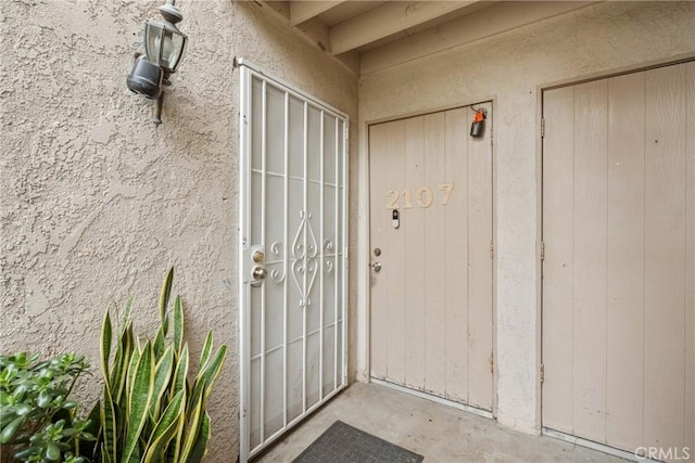 property entrance with stucco siding