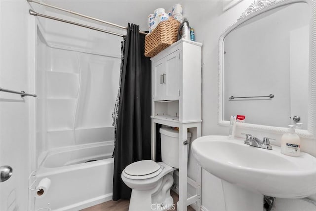 full bath with shower / tub combo with curtain, a sink, and toilet