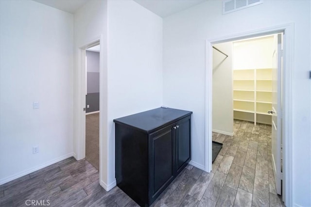 corridor featuring light wood-type flooring, baseboards, and visible vents