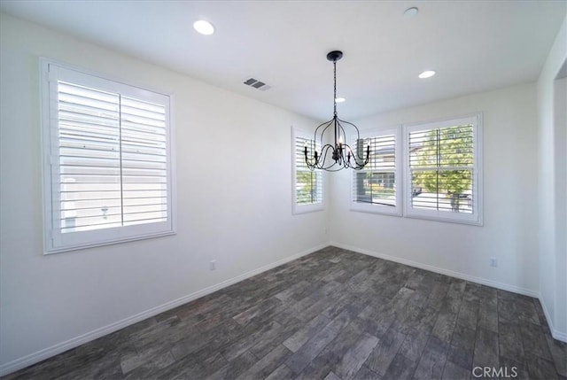 unfurnished dining area featuring an inviting chandelier, baseboards, dark wood-style floors, and visible vents