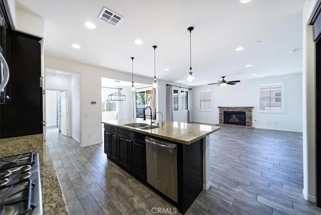 kitchen with dark wood-style flooring, visible vents, dark cabinetry, dishwasher, and a sink