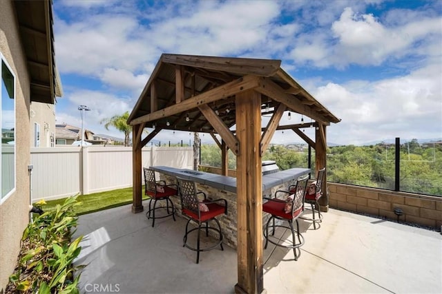 view of patio / terrace featuring a gazebo, outdoor dry bar, and fence