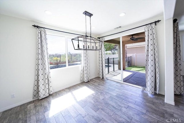 unfurnished dining area with visible vents, baseboards, and wood finished floors