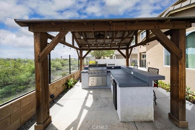 view of patio / terrace with a gazebo, exterior kitchen, outdoor wet bar, area for grilling, and fence
