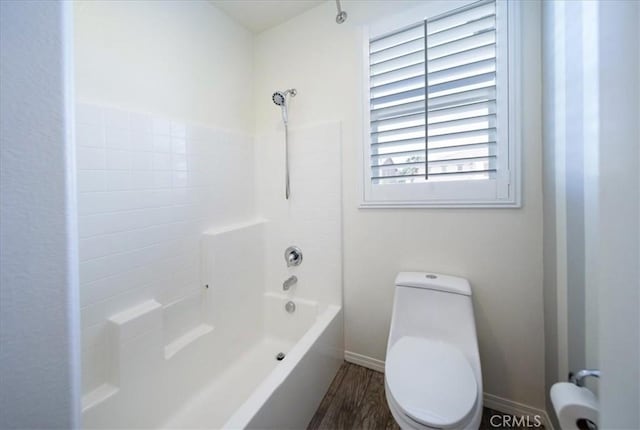 bathroom with shower / tub combination, baseboards, toilet, and wood finished floors
