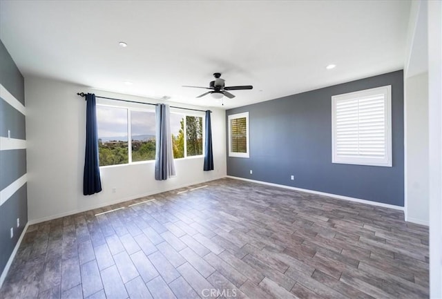 spare room featuring baseboards, a ceiling fan, and wood finished floors