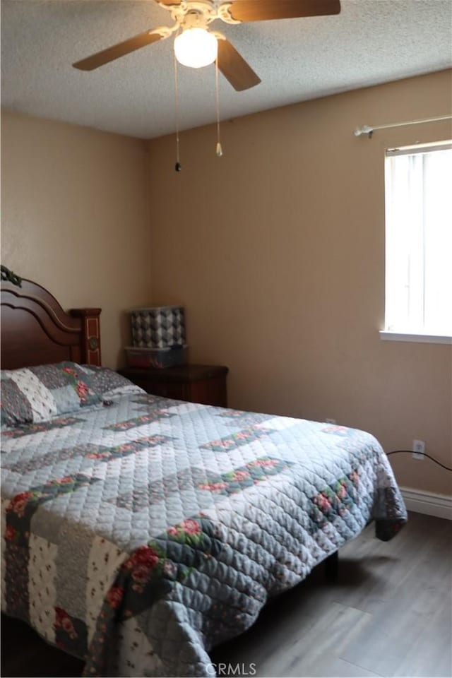 216 Barros St, Patterson, CA 95363 - bedroom featuring a textured ceiling, baseboards, a ceiling fan, and wood finished floors