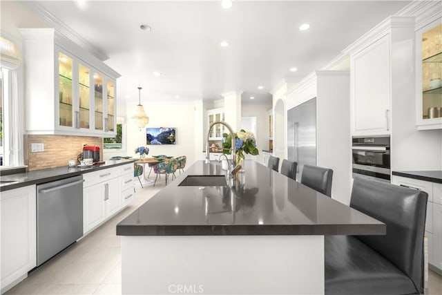 5366 Collingwood Cir, Calabasas, CA 91302 - kitchen featuring stainless steel dishwasher, dark countertops, a kitchen island with sink, tasteful backsplash, and recessed lighting