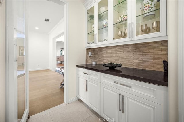 5366 Collingwood Cir, Calabasas, CA 91302 - bar featuring decorative backsplash, baseboards, crown molding, arched walkways, and light tile patterned floors