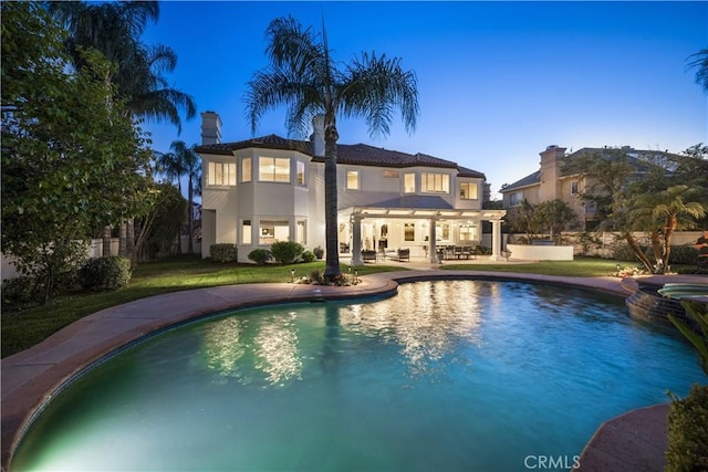 5366 Collingwood Cir, Calabasas, CA 91302 - rear view of house featuring a patio, a pool with connected hot tub, stucco siding, and a yard