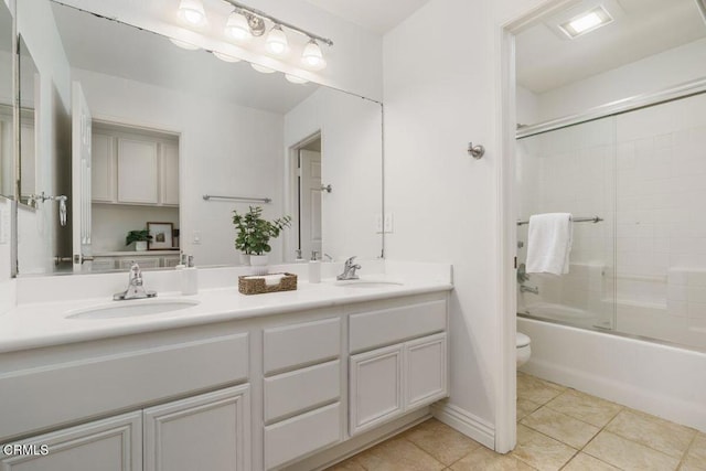 bathroom with double vanity, toilet, tile patterned floors, and a sink