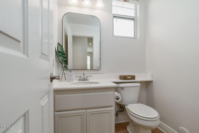 half bath featuring vanity and toilet