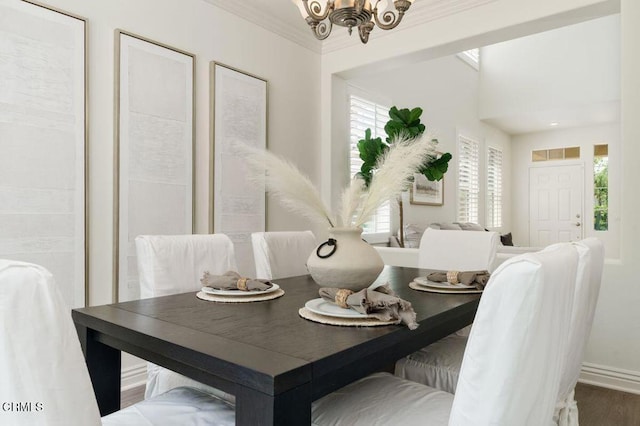 dining area with baseboards, wood finished floors, and a notable chandelier