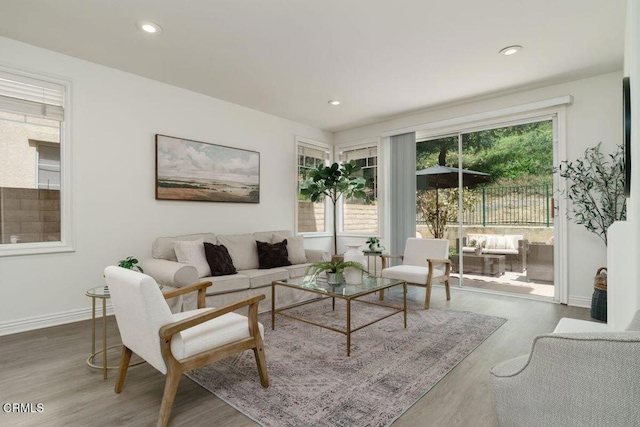 living area with a healthy amount of sunlight, recessed lighting, and wood finished floors