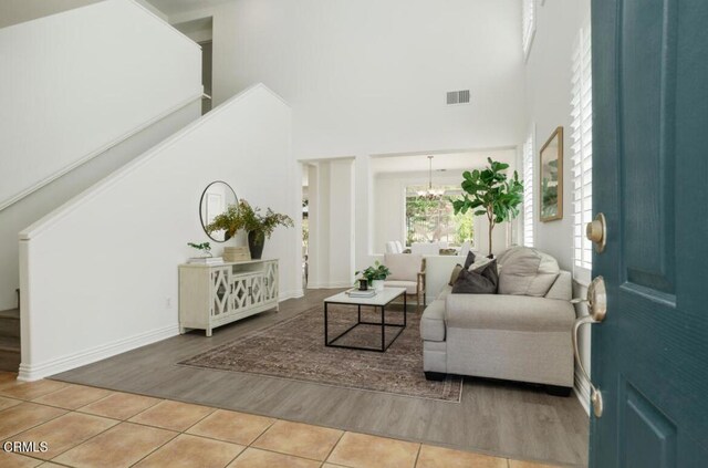 570 Shadow Ln, Simi Valley, CA 93065 - living area with stairs, a high ceiling, light wood finished floors, a chandelier, and baseboards