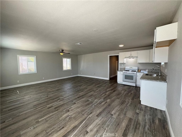 kitchen featuring a sink, white range with gas cooktop, ceiling fan, under cabinet range hood, and dark wood-type flooring