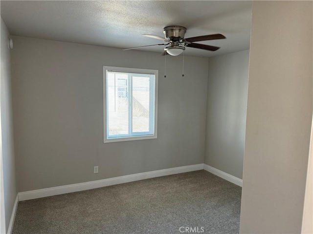 unfurnished room featuring carpet floors, a ceiling fan, and baseboards