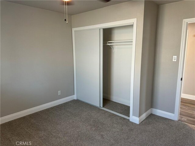 unfurnished bedroom featuring a closet, carpet flooring, and baseboards