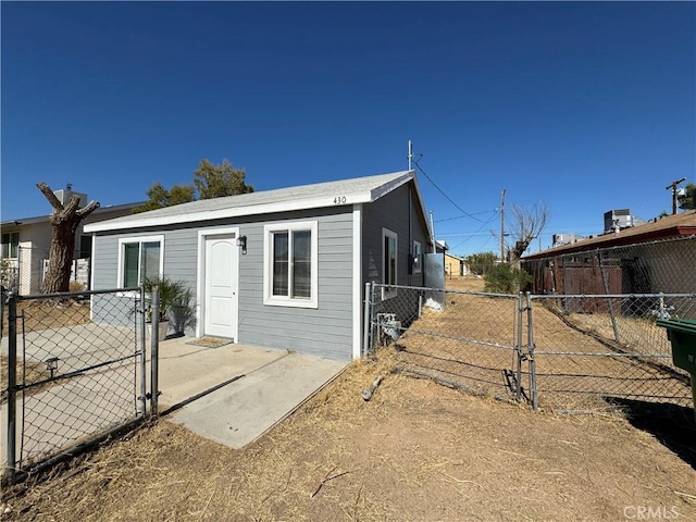 view of front of house featuring a gate, fence, and a patio