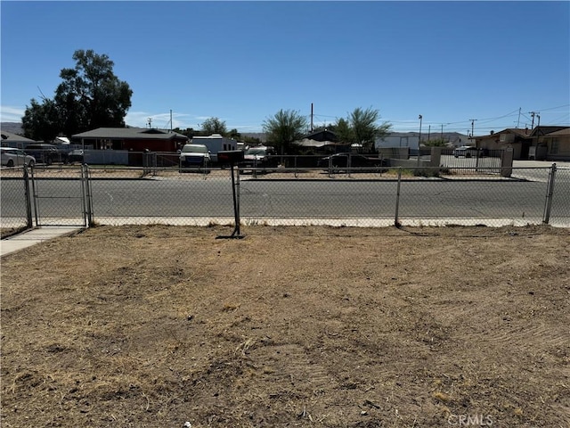 view of yard featuring a gate, fence, and a residential view