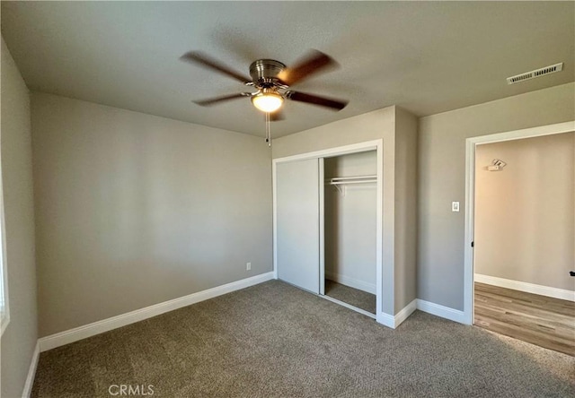 unfurnished bedroom featuring baseboards, visible vents, carpet floors, and a closet