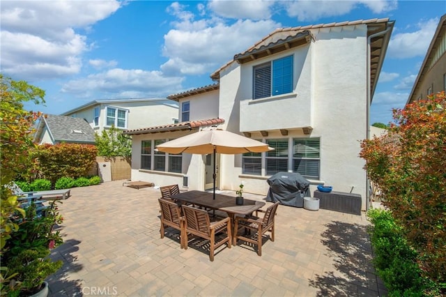 132 Carrotwood, Irvine, CA 92618 - rear view of house featuring stucco siding, a patio, outdoor dining space, and a tiled roof