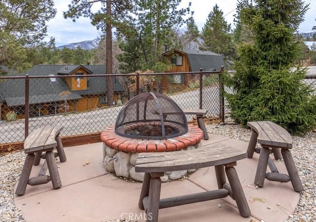 view of patio / terrace with fence, an outdoor fire pit, and a mountain view