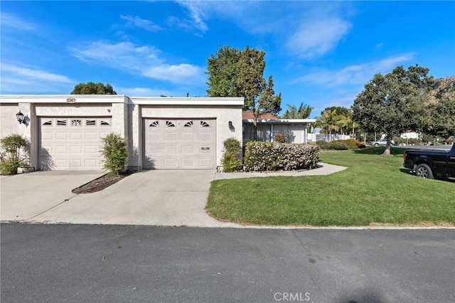 view of front of house with concrete driveway, stucco siding, a garage, and a front yard